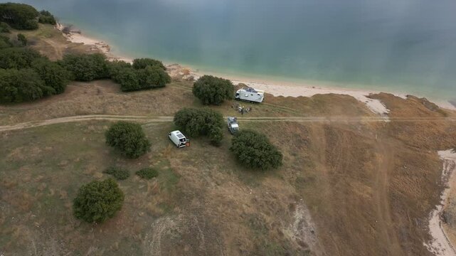 Camper vans parked on a wild spot in Lake Polyfyto drone aerial view in Greece