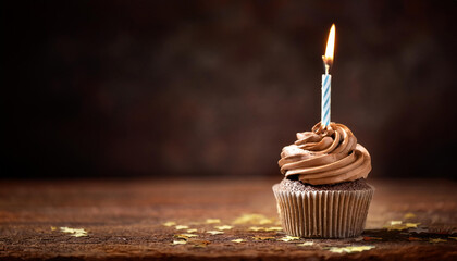 birthday cupcake with candle on dark historical past