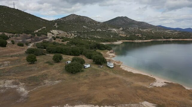 Camper vans parked on a wild spot in Lake Polyfyto drone aerial view in Greece