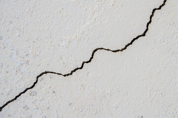 white painted wall with a diagonal crack