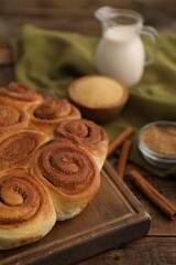 Freshly baked cinnamon rolls on wooden table, closeup