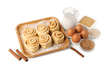 Raw cinnamon rolls and different ingredients isolated on white