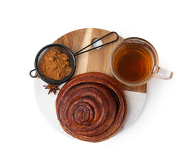 Delicious cinnamon roll bun, tea and spices isolated on white, top view