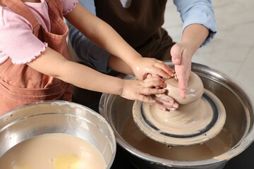Hobby and craft. Mother with her daughter making pottery indoors, closeup