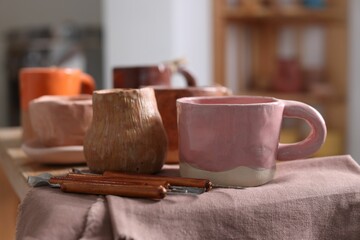 Set of different crafting tools and pottery on shelf indoors, closeup