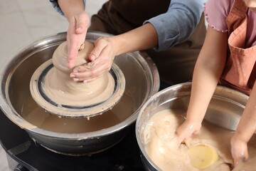 Hobby and craft. Mother with her daughter making pottery indoors, closeup
