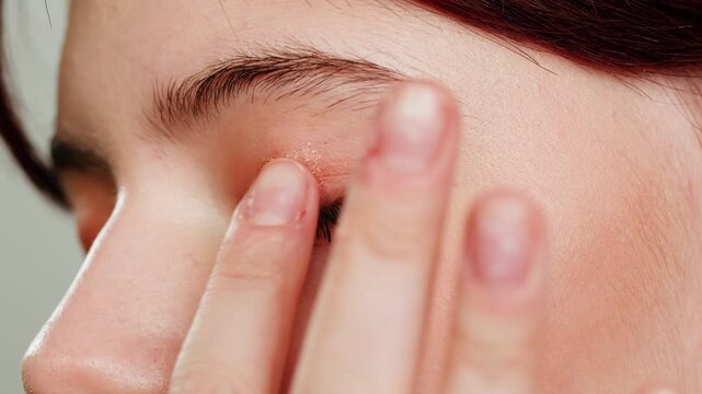 Eye shadow makeup to the upper eyeliner, close-up. Makeup artist applies a bright eye shadow with a makeup brush.Tutorial master class of professional makeup. 