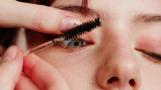 Eye shadow makeup to the upper eyeliner, close-up. Makeup artist applies a bright eye shadow with a makeup brush.Tutorial master class of professional makeup. 