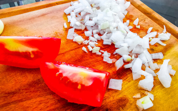 Tomatoes and onions sliced on a cutting board in Mexico.