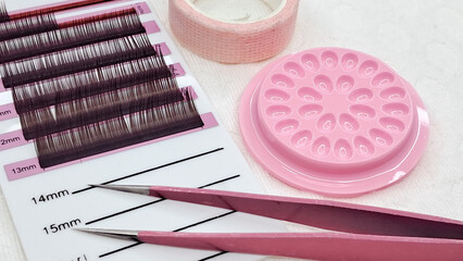 A variety of eyelash extension materials and tools laid out for use.