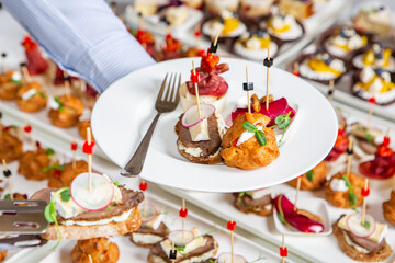 Catering buffet or service with different snacks, appetizers and canapes on a table. Variety of Freshly Prepared Catering Food for an Event.