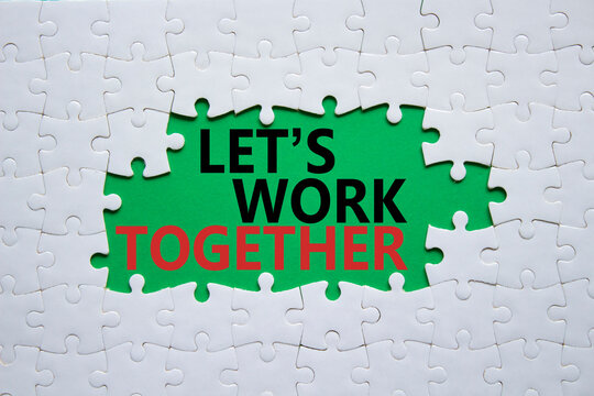 Lets work together symbol. Concept words Lets work together on white puzzle. Beautiful green background Business and Lets work together concept. Copy space.