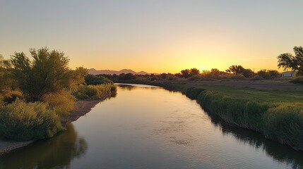 Obraz premium Serene Sunset River Landscape with Distant Mountains