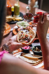 Person assembling a taco in a traditional Mexican eatery