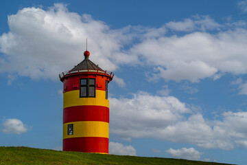 Sommerhimmel über dem rot-gelben Leuchtturm