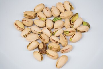 Pistachio nuts on a white plate – healthy snack concept