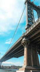 Fototapeta premium Dramatic view of base of Williamsburg Bridge pillar against blue sky, landmark, pillar, NYC