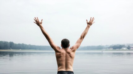 Fototapeta premium Man With Arms Raised Enjoying Peaceful Lake Scenery