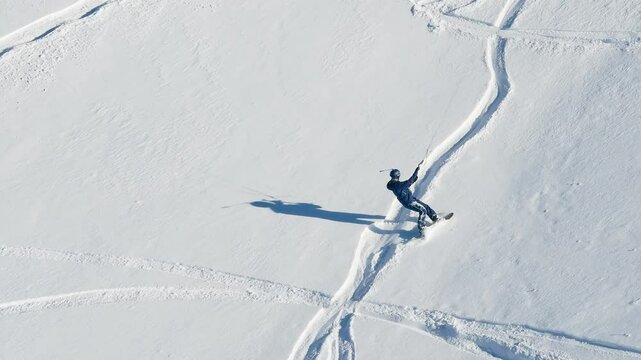 Aerial drone view of a sportsman snowkiting on the Giau Pass in the Dolomites, Italy