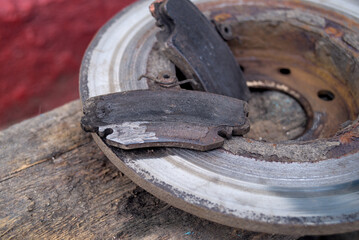 Old worn out car brake disc and brake pads