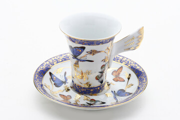 Fototapeta premium Delicate porcelain teacup featuring vibrant butterfly pattern and gilded accents, highlighting elegant tea-drinking experience