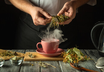 Herbalist prepares medicinal herbal tea on the kitchen table. Prevention of viral diseases with...