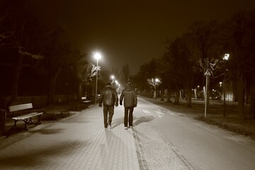 two men lit from the front on a night walk, black and white photo