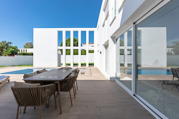 an outdoor image overlooking a dining table and swimming pool in luxury mediterranean villa garden 