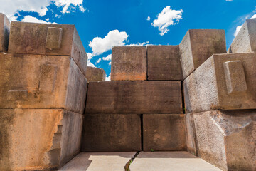 Muros de piedra incaica con bloques encajados perfectamente bajo cielo azul. Arquitectura antigua y misterio arqueológico.