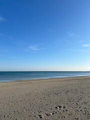 Obraz premium Sand beach and blue sky. Clean fine sand, sea coast, blue-blue sky. Beautiful seascape. Clean beach