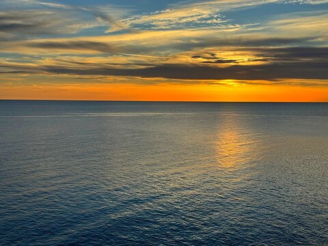 Orange sunset sky over blue sea at evening.