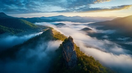 Naklejka premium Misty Mountain Peaks Rising Above Foggy Valley at Dawn