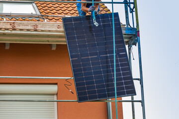 Installing solar panels on a roof. Solar panels on roof. Workers installing solar cells.