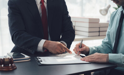 Legal Contract Signing: A close-up shot of a man signing a legal document in a professional...