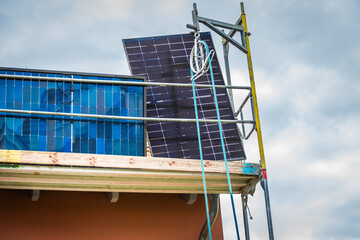 Installing solar panels on a roof. Solar panels on roof. Workers installing solar cells.