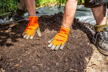 Installing weed control fabric material and bark mulch in a residential garden to control weed...