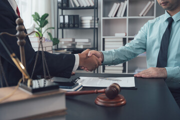 Legal Handshake: A lawyer and client shake hands across a desk, signifying a successful agreement...