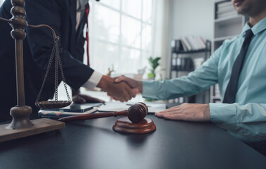 Legal Handshake:  A close-up shot of a lawyer and client shaking hands across a desk, symbolizing...