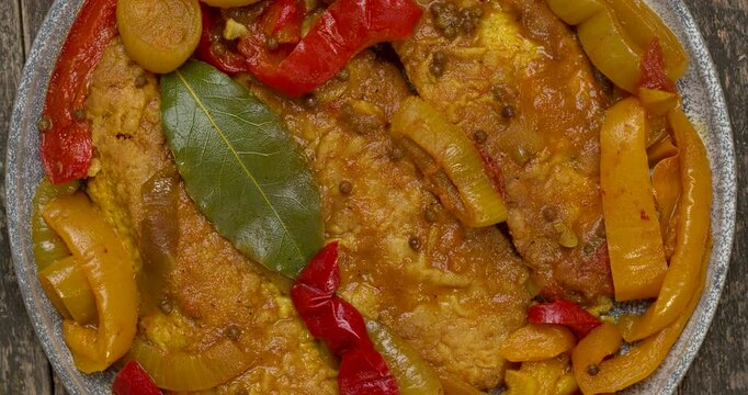 Top view of marinated sweet and sour fish with vegetables. Table spin. 