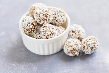 Healthy raw energy balls with cocoa, coconut, sesame, chia on white background. Healthy homemade paleo chocolate energy balls with rolled oats, nuts, dates. Raw vegan healthy dessert, selective focus