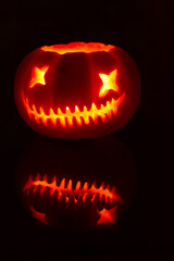 Freshly carved halloween pumpkin on glass table