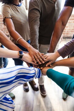Diverse group of people joining hands in unity. Teamwork and collaboration. Hands of different ethnicities coming together in a circle. Unity and diversity. Teamwork, diverse stack of hands as team.