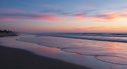 Fototapeta premium Ocean Waves Lapping on Beach at Sunset with Colorful Sky