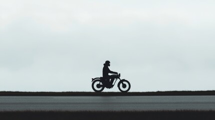 Obraz premium Silhouette of motorcyclist on road, overcast day, outdoor. Suitable for travel, adventure, lifestyle, and transportation advertising