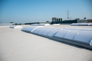 Plastic dome on flat roof on large building, flat roof with many large skylights and modern industrial building © Anna Kondratiuk