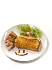 Top-down view Close-up of a breakfast plate with a smiling face made of ketchup, featuring an omelette, sausages and a salad isolated on white.