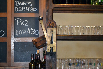Traditional Asturian cider house interior with rustic elements and glasses on display. Large...