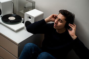 Music vinyl lover listen and enjoy 78 RMP records with turntable player. Man is relaxing with vinyl...