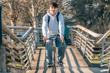 young man or student on the street riding a bicycle