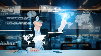 Professional project manager looking and holding business data and checking financial chart. Smart business man wearing augmented reality goggles by using AI technology at modern office. Ingenuity.